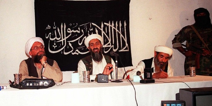 Osama bin Laden und Mitstreiter von Al Qaida vor schwarzer Fahne